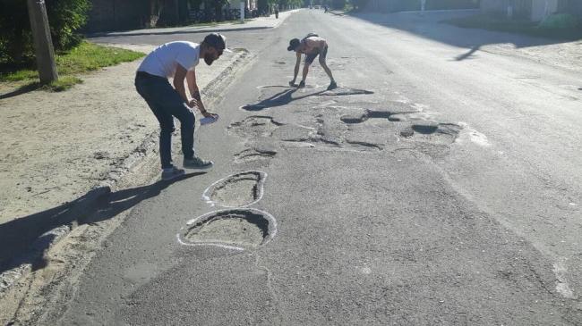 «Доріг у місті немає»: ями на головній вулиці обмалювали фарбою