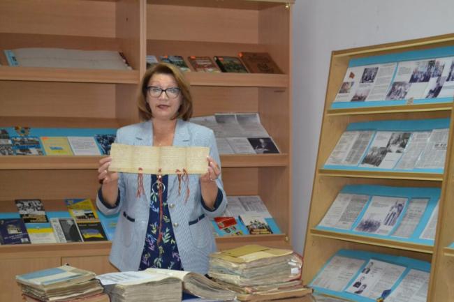 Людмила Леонова показує стародавню грамоту на пергаменті